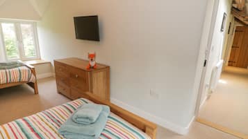 A bedroom with a bed, a dresser, a television, and a window.