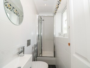 A modern bathroom with a glass-enclosed shower, a white sink, and a toilet. - Huffin (Dartmouth)