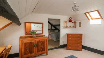 A room with a wooden cabinet, a dresser, a mirror, and a small window.