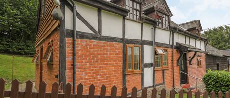 A traditional half-timbered house with exposed brickwork and timber framing.