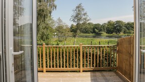 Une terrasse en bois offrant une vue sur une rivière et des arbres.