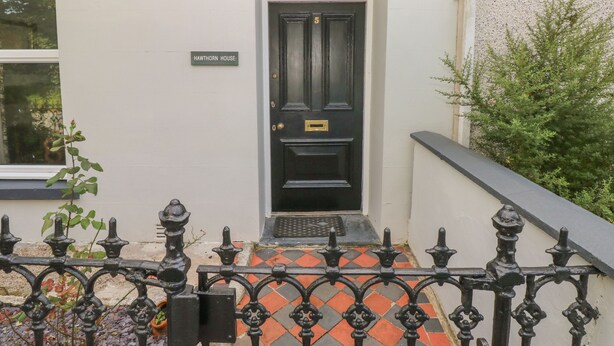 A black door with a brass handle, a small plaque reading "HAWTHORN HOUSE," and a number "5" above the door. - Hawthorn House (Pembroke)