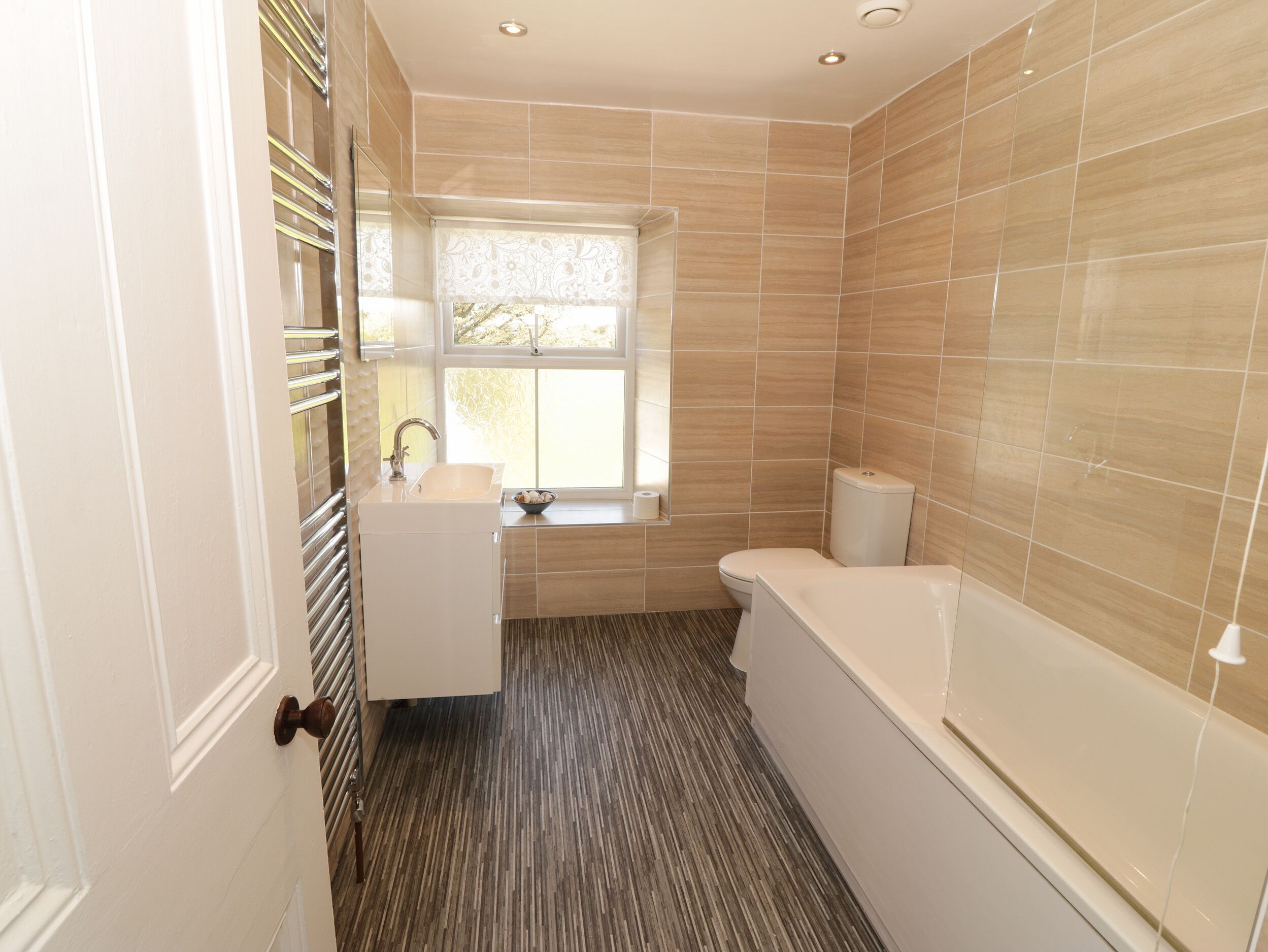 A modern bathroom with a toilet, sink, and bathtub.