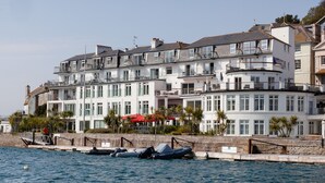 A waterfront hotel with multiple balconies, a marina with boats, and a red umbrella. - 34 The Salcombe (Salcombe)