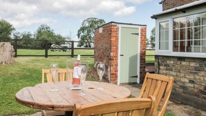 A round wooden table with four chairs, a bottle of wine, and two wine glasses. - Ryeby Garth (Hull)