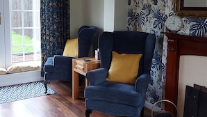A living room with two blue armchairs, a wooden coffee table, and a patterned wallpaper. - Ryeby Garth (Hull)