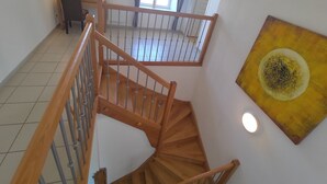 Un escalier en bois avec des rampes en métal menant à l’étage supérieur.