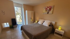 Une chambre à coucher avec un lit, des lampes de chevet, une chaise, une armoire et un tableau au mur.