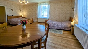 Une pièce chaleureuse avec un lit en bois, un canapé, une table à manger et une fenêtre avec des rideaux.