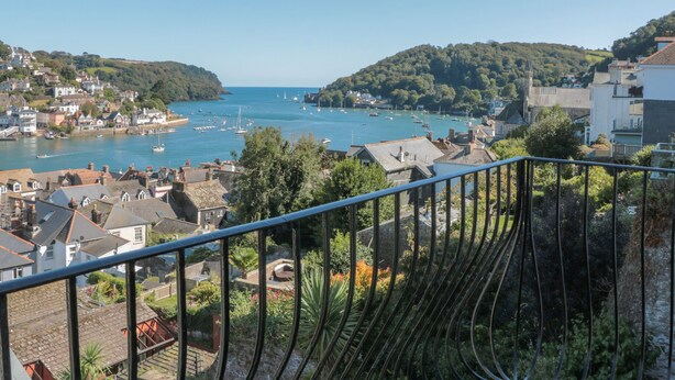 A coastal town with a view of the sea, houses, and a staircase with a metal railing. - 21 Above Town (Dartmouth)