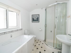 A modern bathroom with a bathtub, toilet, and glass shower enclosure. - 21 Above Town (Dartmouth)