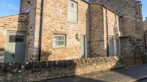 A stone building with a green door, a window with a shutter, and a small balcony. - White Lea (Richmond)