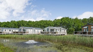 Eine Reihe von Mobilheimen mit einem Teich im Vordergrund.