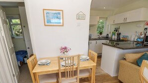 A compact living space with a dining area, kitchenette, and a sofa.
