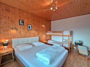 A room with wooden walls, a bunk bed, a bedside table with a lamp, and a small desk with a chair. - Independent house with garden, terrace and fireplace in Saulxures-sur-Moselotte (Saulxures-sur-Moselotte)