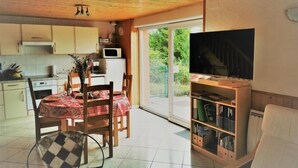 A compact living space with a kitchen, dining area, and a TV. - Independent house with garden, terrace and fireplace in Saulxures-sur-Moselotte (Saulxures-sur-Moselotte)