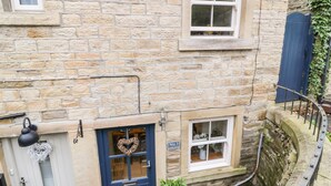 A stone building with a blue door, a heart-shaped decoration, and a sign reading "No. 1 Oakleys". - 1 Oakleys (Holmfirth)