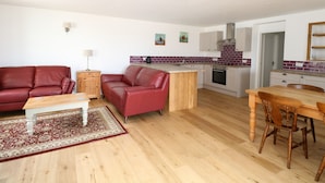 A modern apartment with a living room, dining area, and kitchen. - Waveney View Cottage (Great Yarmouth)