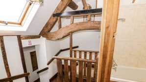 A wooden staircase with a view of a bathroom. - Wilstone Cottage (Church Stretton)
