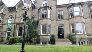 A historic building with multiple windows and a green sign indicating 'Grosvenor House'. - 2B Cavendish Villas (Buxton)