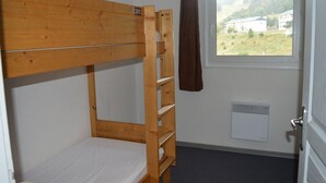 A bunk bed in a room with a window and a radiator. - T3 Apartment at the foot of the slopes with covered parking (Les Angles)