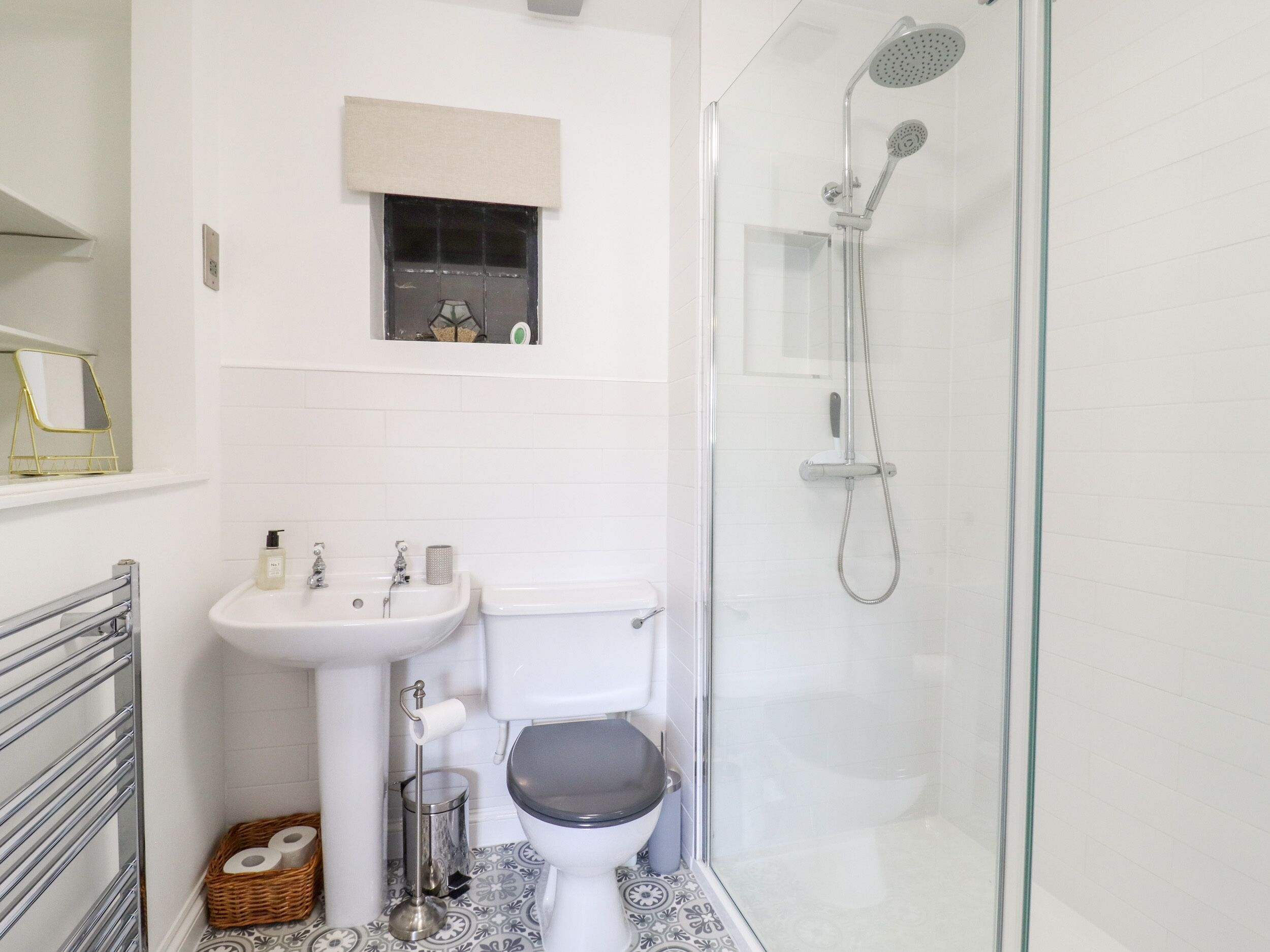 A bathroom with a toilet, sink, and glass-enclosed shower.