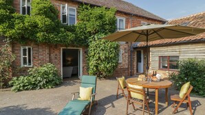 A patio with a table, chairs, and a sun umbrella. - The Granary (Bedford)
