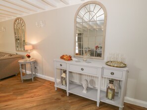 A white console table with a mirror, a lamp, and decorative items. - The Granary (Bedford)
