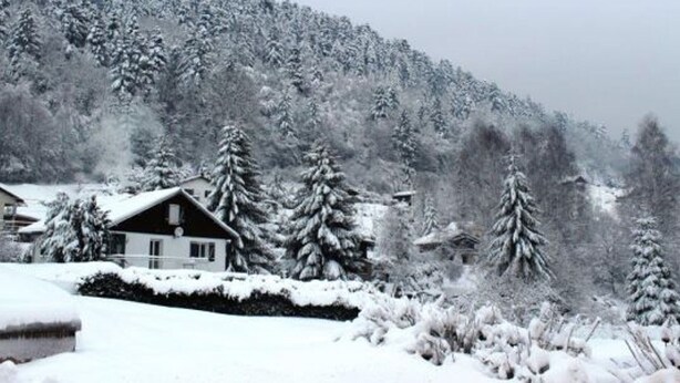 A snow-covered landscape with a house surrounded by trees. - Cozy Village Retreat with Private Pond, Terrace, and Family Amenities in Le Ménil (Le Menil)