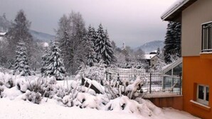 A snow-covered landscape with a building that has a sloped roof and a window. - Cozy Village Retreat with Private Pond, Terrace, and Family Amenities in Le Ménil (Le Menil)