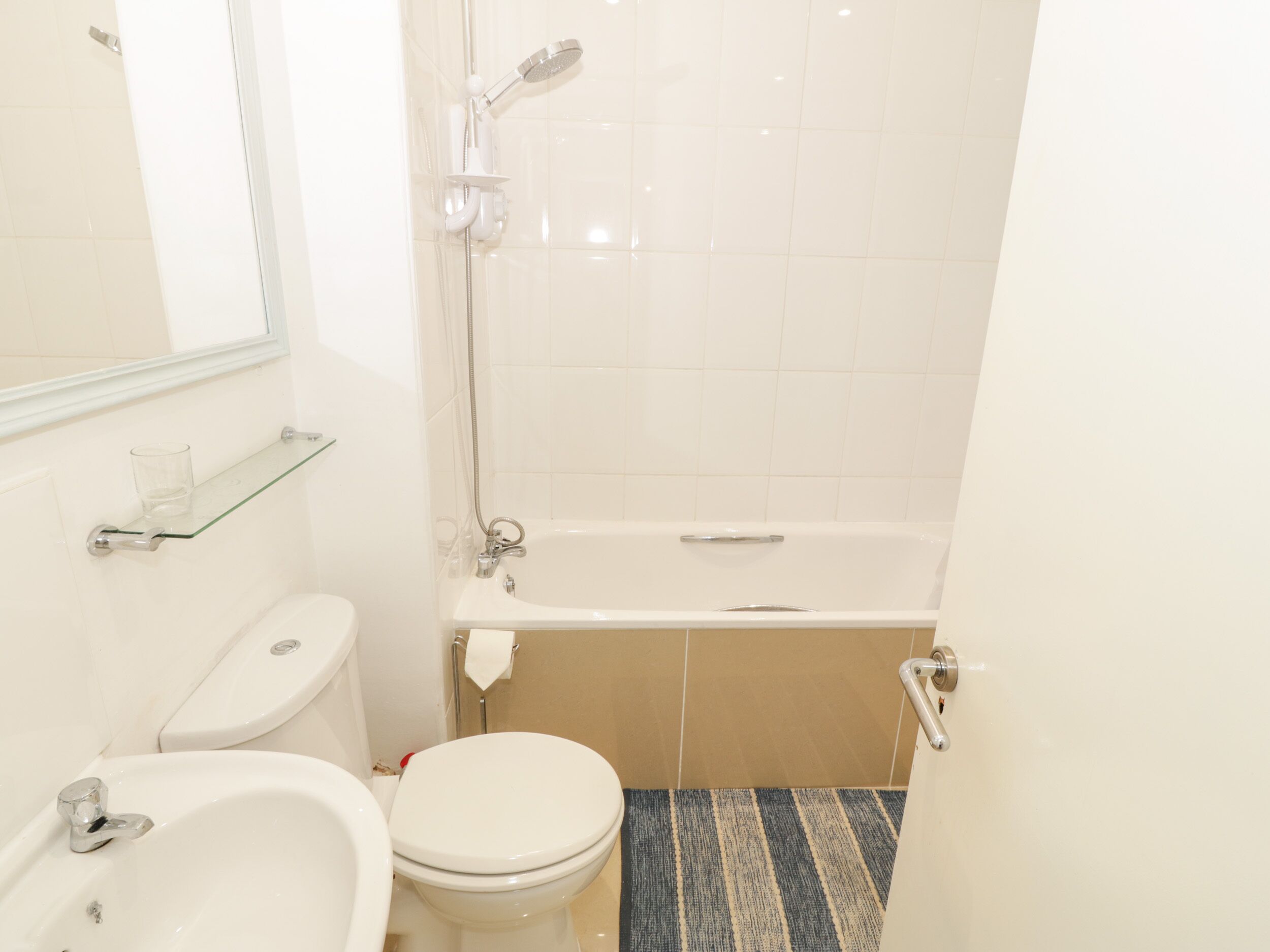 Ein kleines, sauberes Badezimmer mit Toilette, Waschbecken und Badewanne.