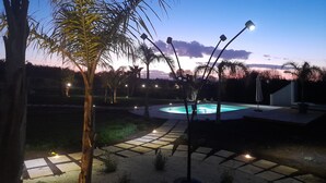 A pool area with a paved walkway, palm trees, and street lamps. - Trullo new villa with private heated pool near Salento beaches (Ugento)