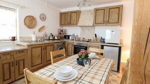 Una cocina moderna con armarios de madera, una isla central y un comedor con mantel escocés.