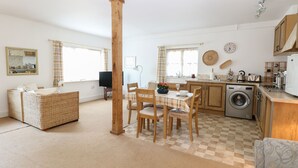 Un espacio habitable compacto con comedor, sofá, lavadora y cocina.