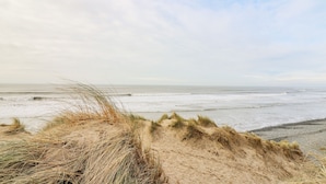 A beach with sand dunes and the ocean in the background. - Ystwyth 26 (Borth)