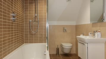 Un baño con bañera, inodoro y lavamanos.