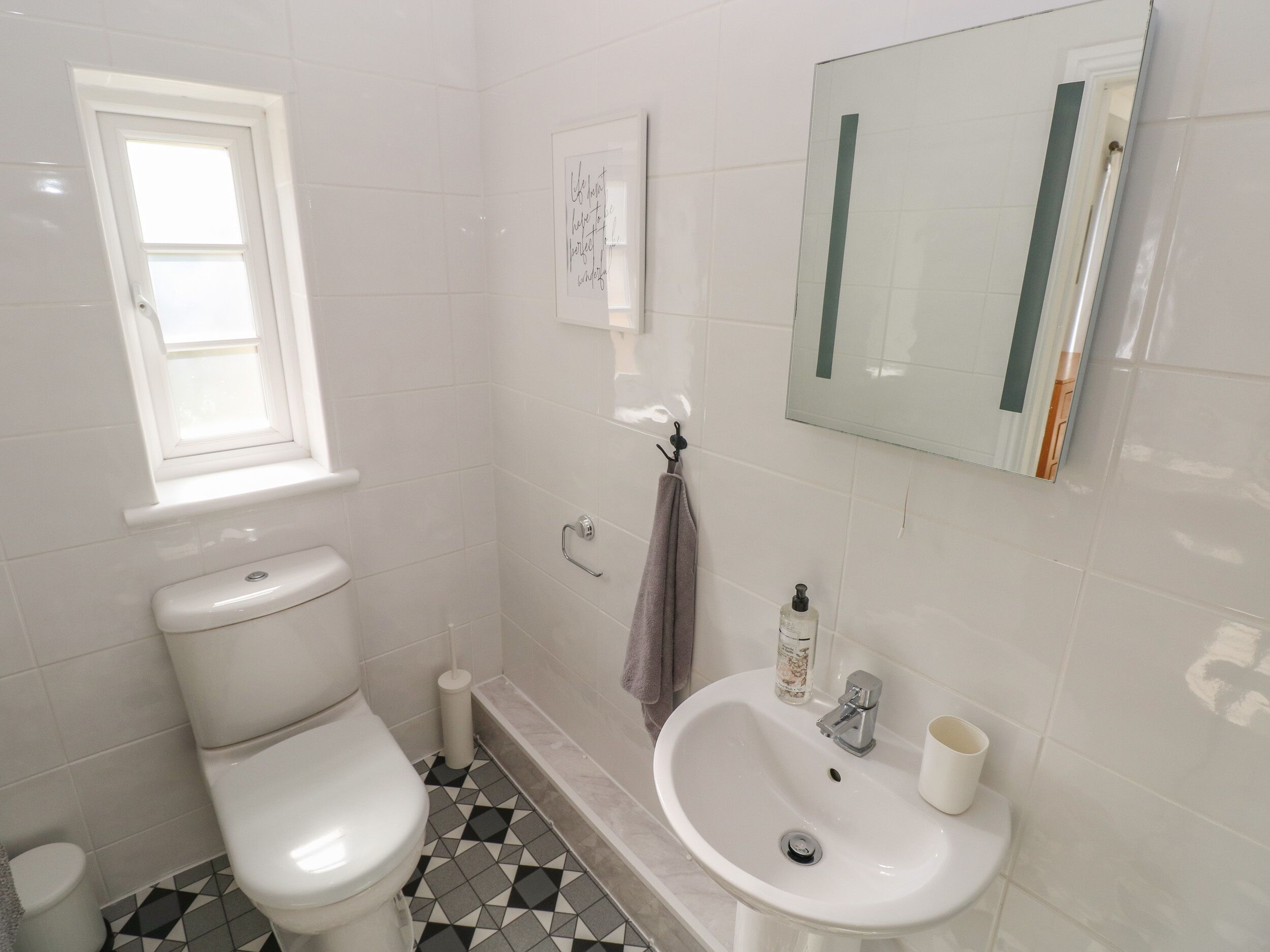 Un bagno con il water, un lavandino e una finestra.