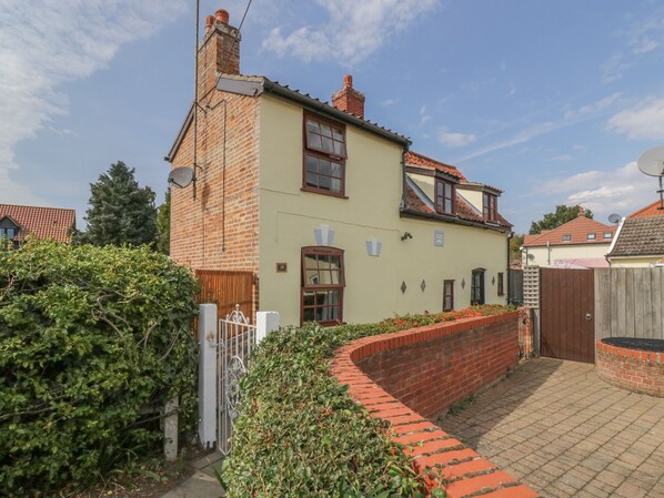 A two-story house with a brick chimney, a satellite dish, and a gated driveway. - Rose Cottage (Ipswich)