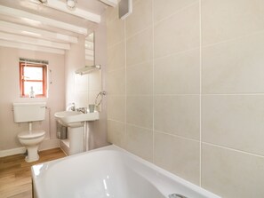 A bathroom with a bathtub, toilet, and sink. - Rose Cottage (Ipswich)