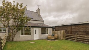 A house with a small garden, a wooden fence, and a bench. - Bron Gadair (Llanfairpwllgwyngyll)