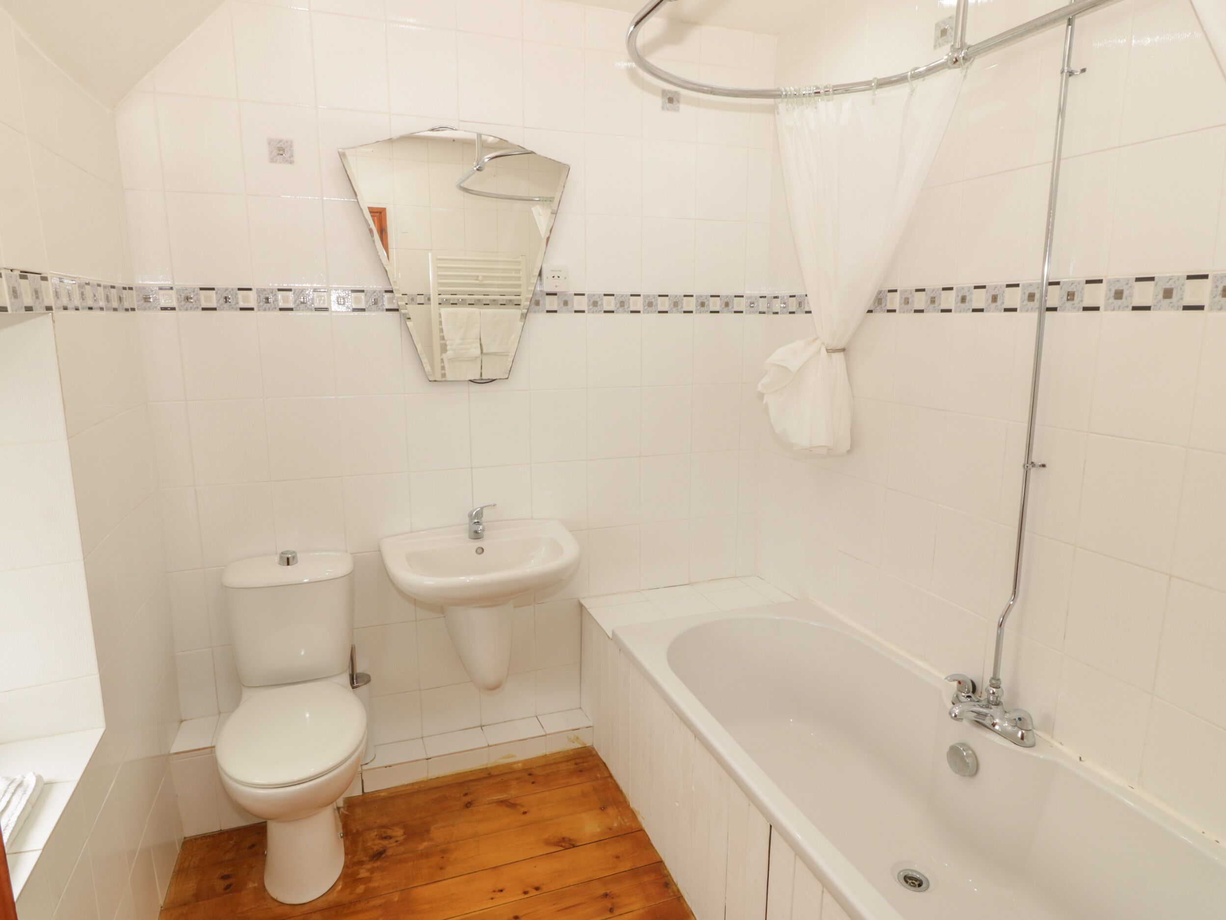A bathroom with a toilet, sink, and bathtub.