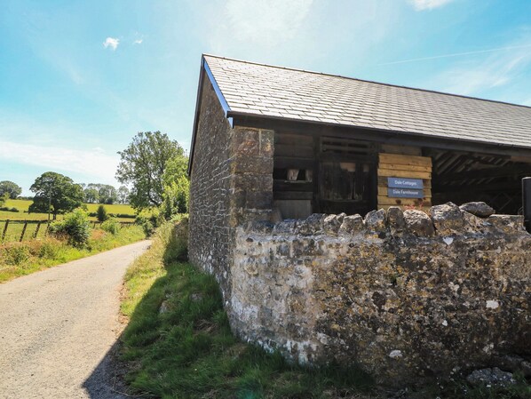 A stone building with a wooden sign indicating 'Dale Cottages' and 'Dale Farmhouse.'