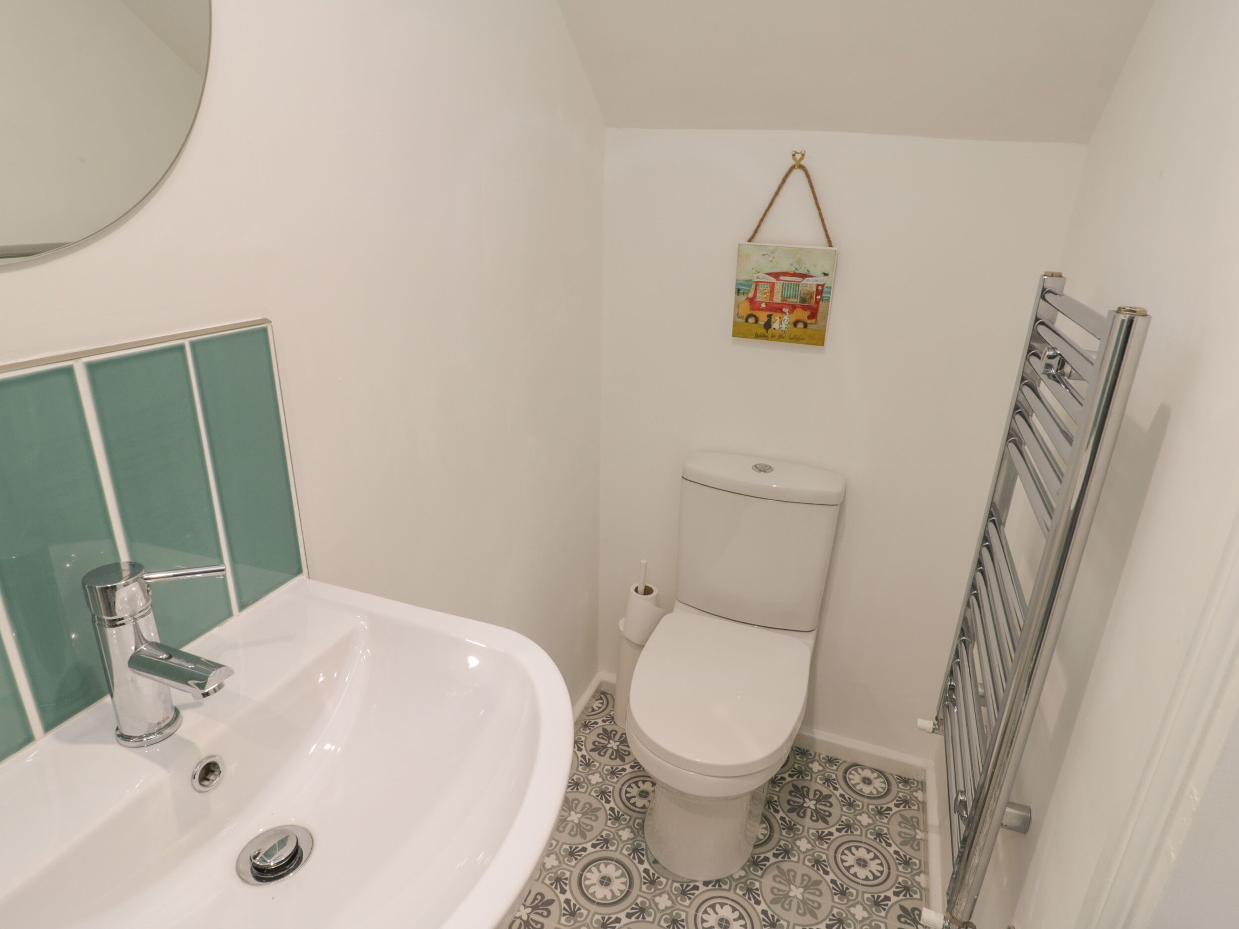 A bathroom with a white sink, a toilet, and a radiator.
