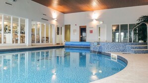 An indoor swimming pool with clear blue water, tiled walls, and a wooden ceiling. - 17 Burgh Island Causeway (Kingsbridge)