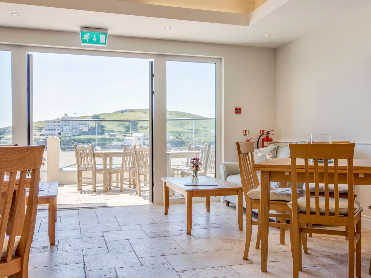 A hotel room with a balcony, wooden furniture, and a view of the countryside.