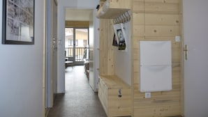 En hall med träpanel på väggarna, en vit dörr och ett inramat foto på vänster sida.