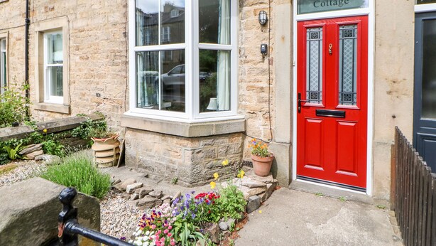 A stone building with a red door labeled "Cottage." - Hawthorne Cottage (Barnard Castle)