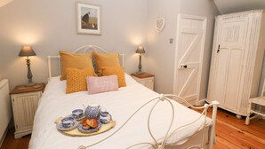 A bedroom with a bed, two bedside tables, a nightstand, a dresser, and a wardrobe. - Millstream Cottage (Hope Valley)