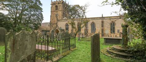 Eine Kirche mit einem hohen Turm und einem Friedhof davor.