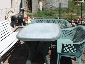 Una mesa de plástico verde y dos sillas en un entorno exterior.